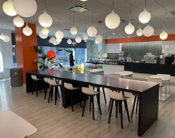 Long communal table and globe pendant lights inside Peach’s at University